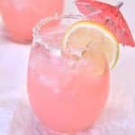 Pink Señorita Cocktail with lemon wheel and umbrella.