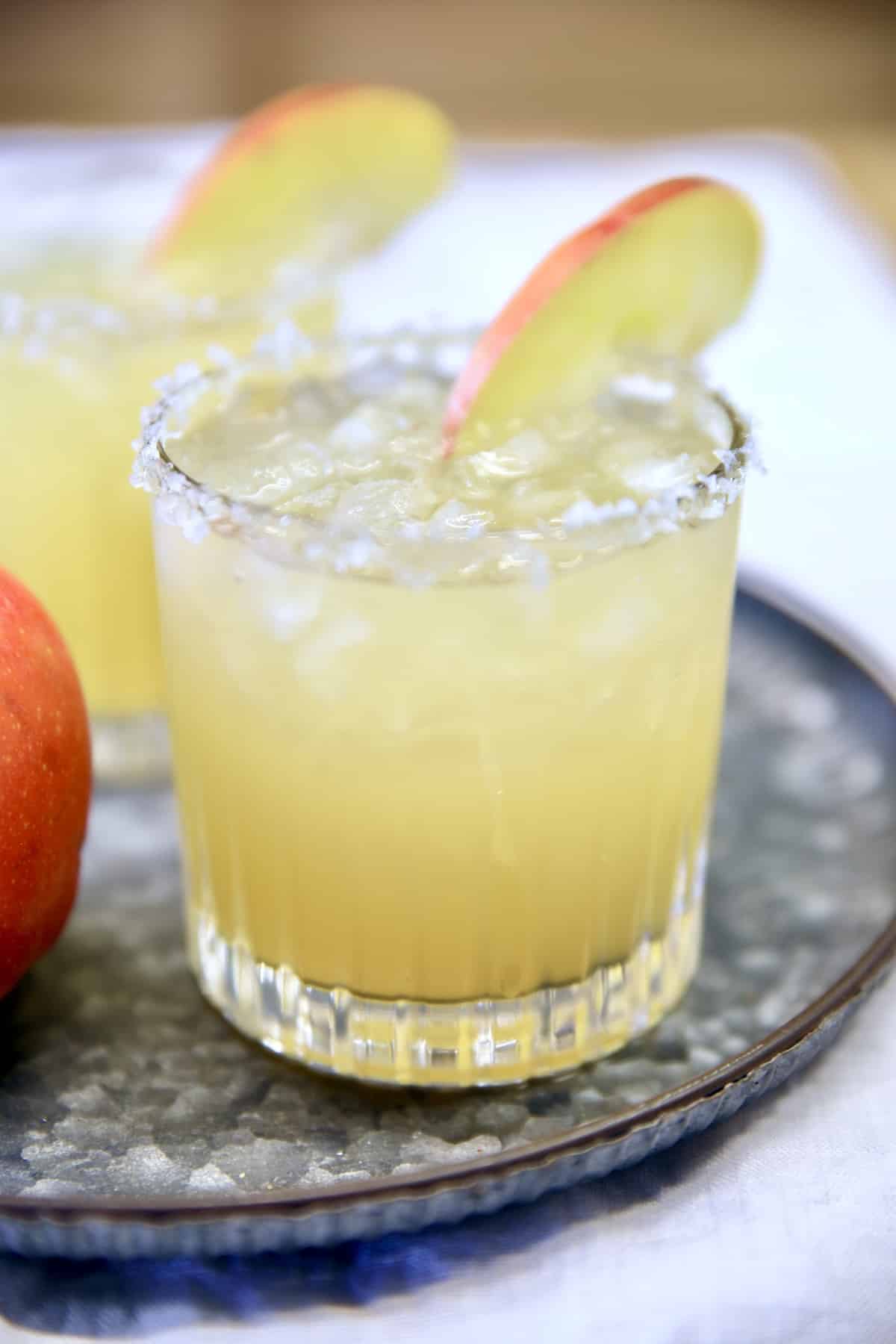 2 fall margaritas with apple garnish on a try.