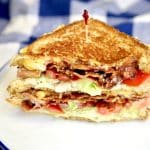 BLT Grilled Cheese Sandwich, cut in half, stacked.