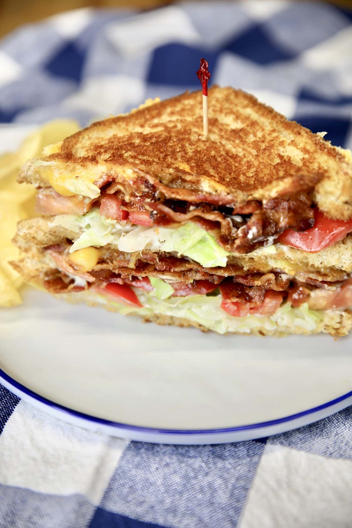 Sliced BLT grilled cheese on a plate.