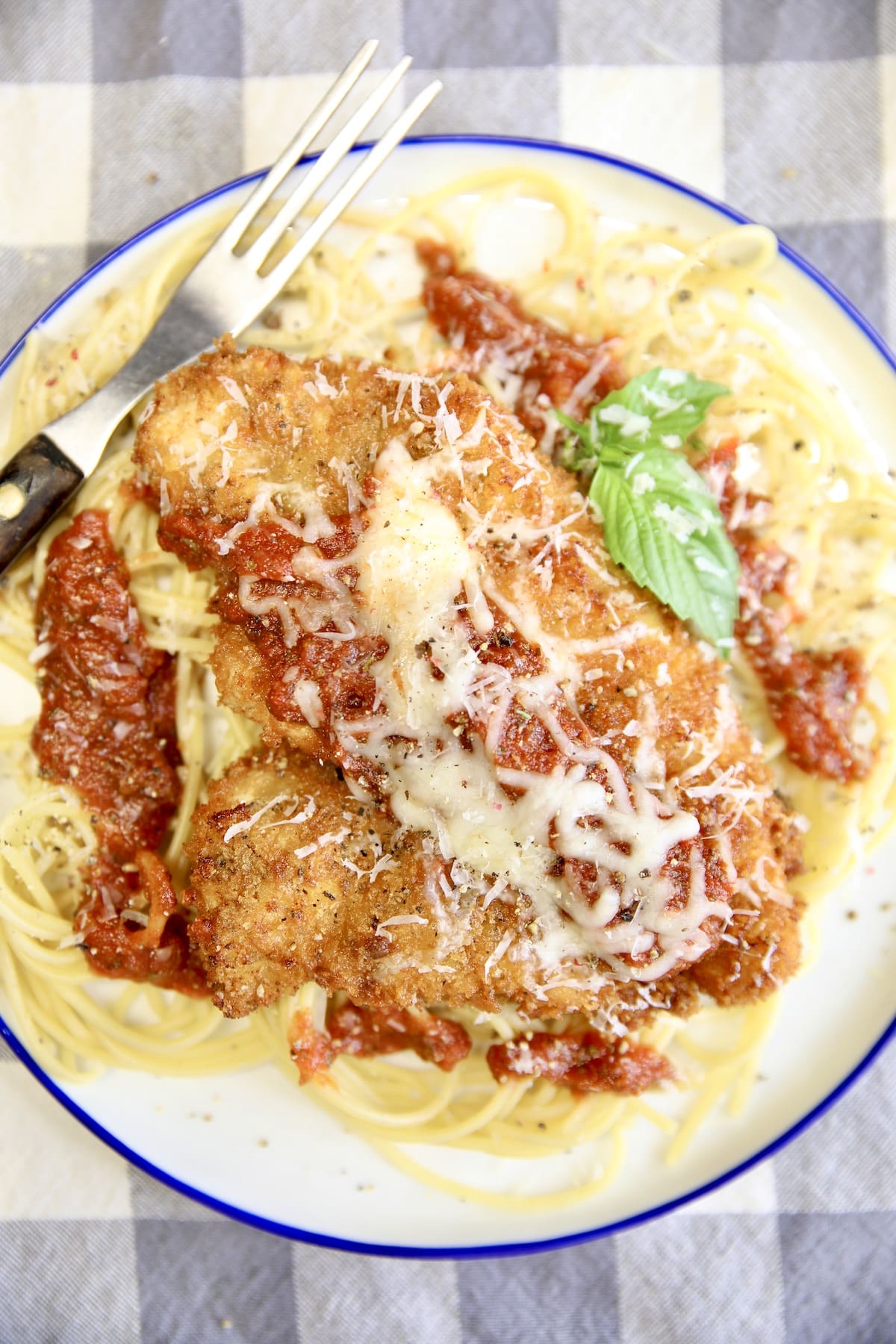 Chicken parmesan with spaghetti on a plate.
