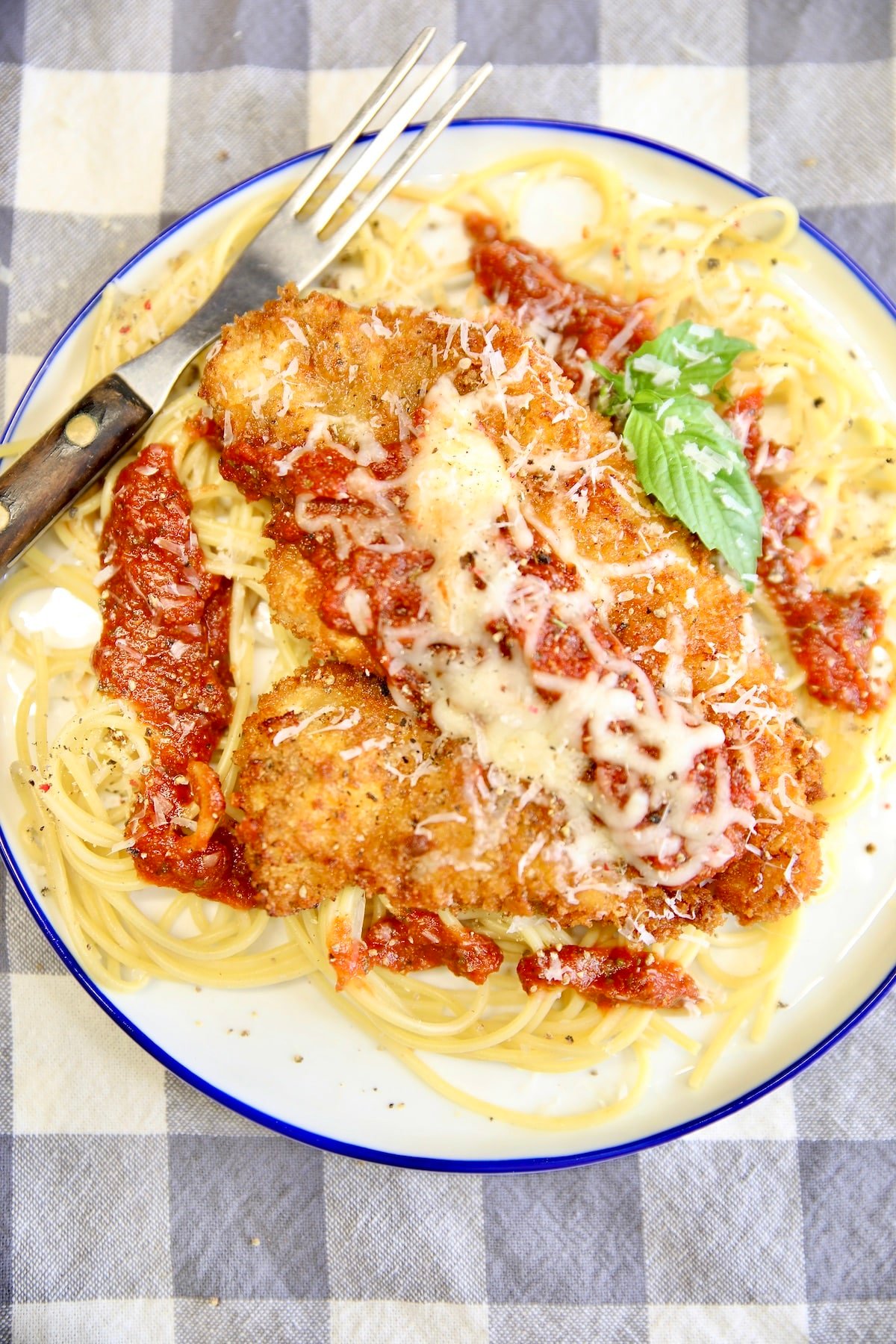 Plate of chicken parmesan with spaghetti.