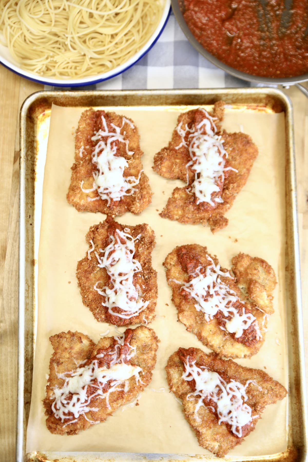 Chicken parmesan on a sheet pan, spaghetti, marinara.