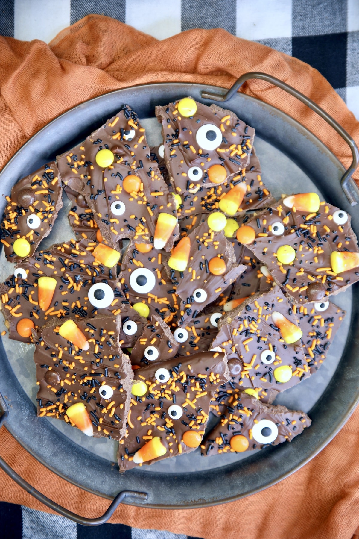 Halloween bark on a platter with candies and sprinkles.