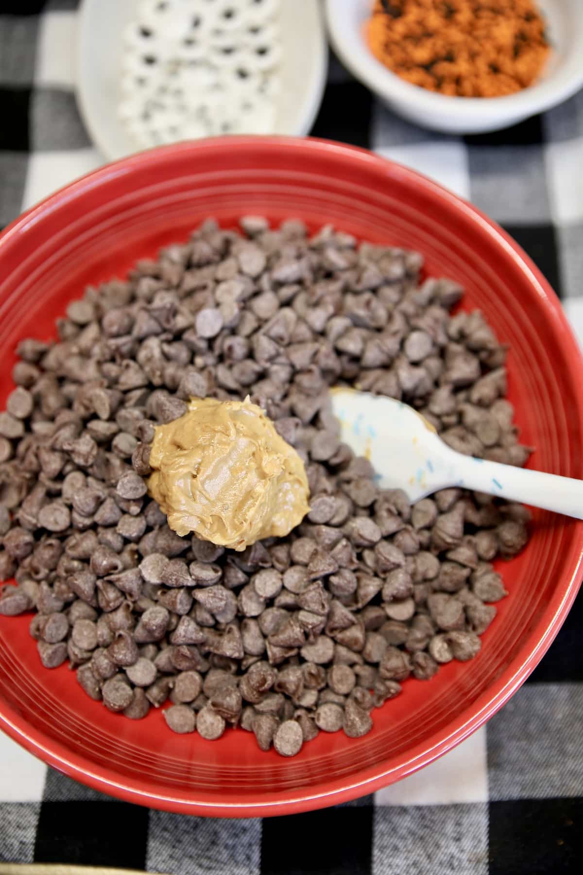 Chocolate chips and peanut butter in a bowl with rubber spatula.