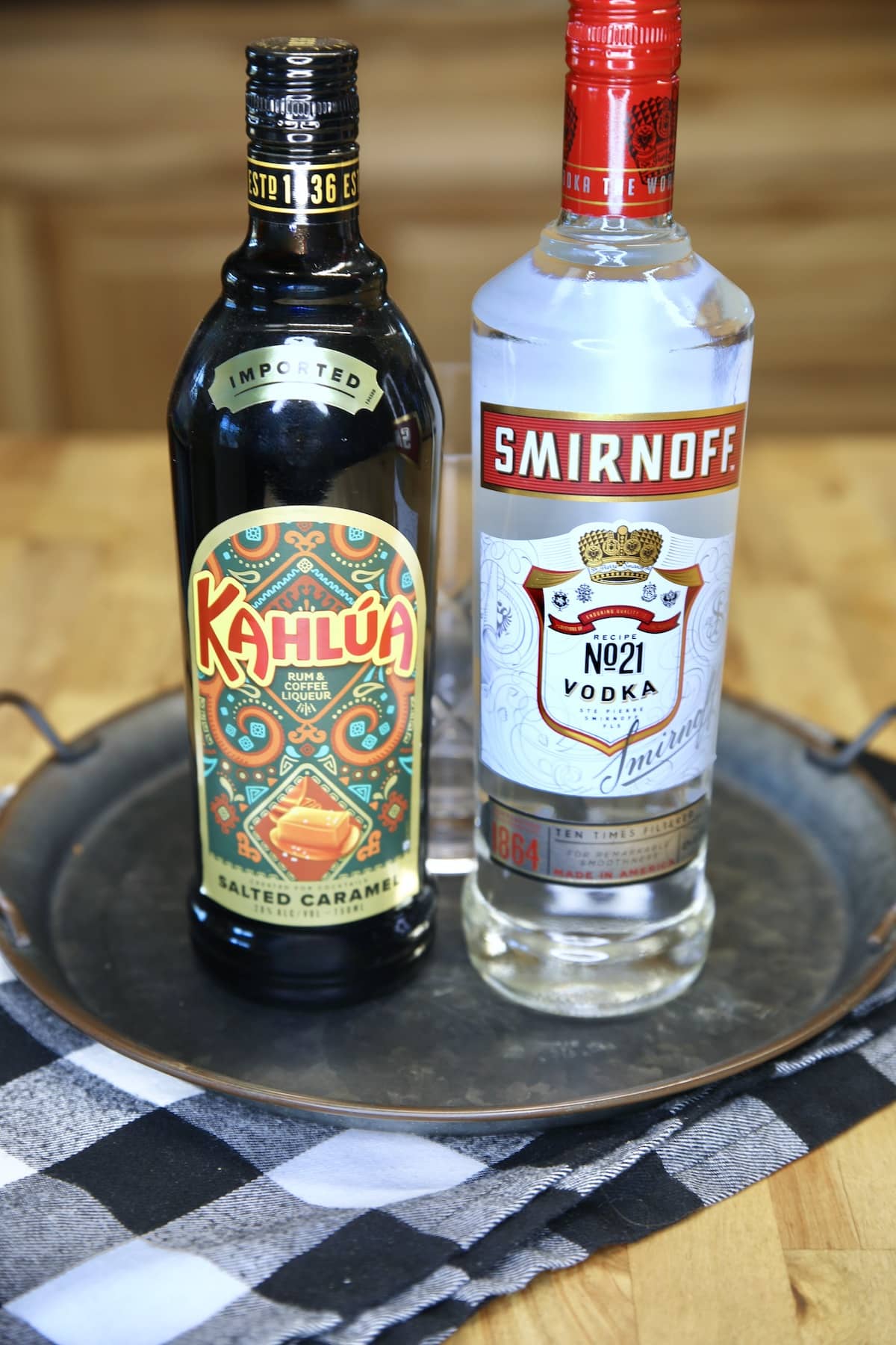 Bottle of Kahlua and bottle of vodka on a tray.