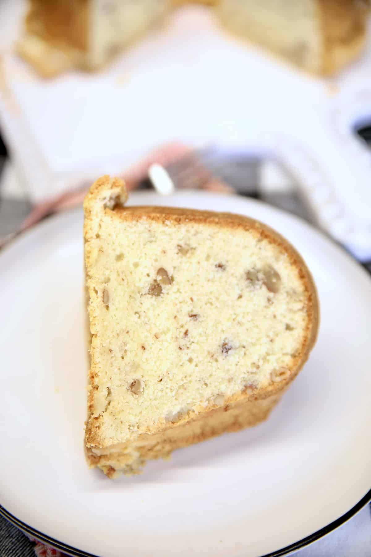 Slice of pecan pound cake on a plate.