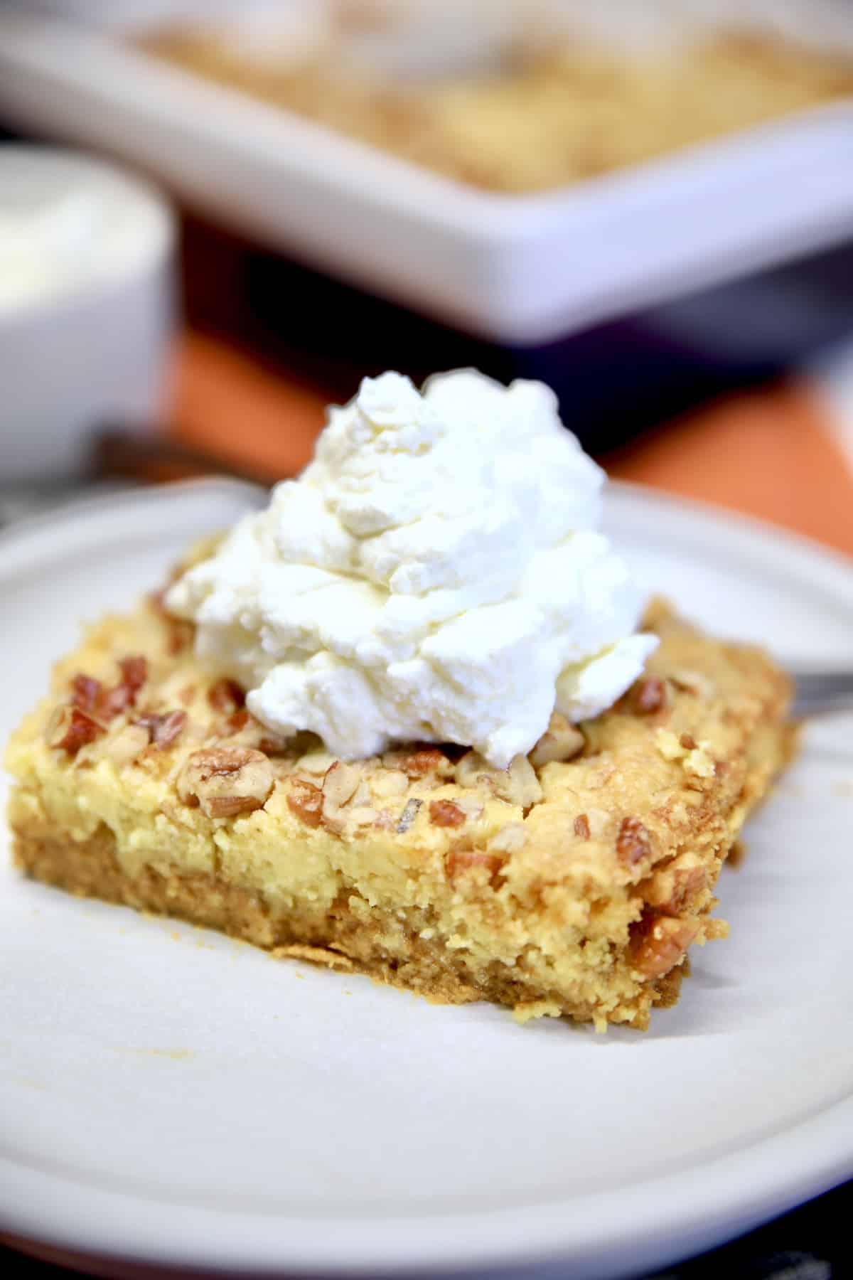 Pumpkin Pie Cake on a plate with whipped cream.