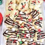 Spritz cookies decorated with chocolate drizzle and sprinkles.