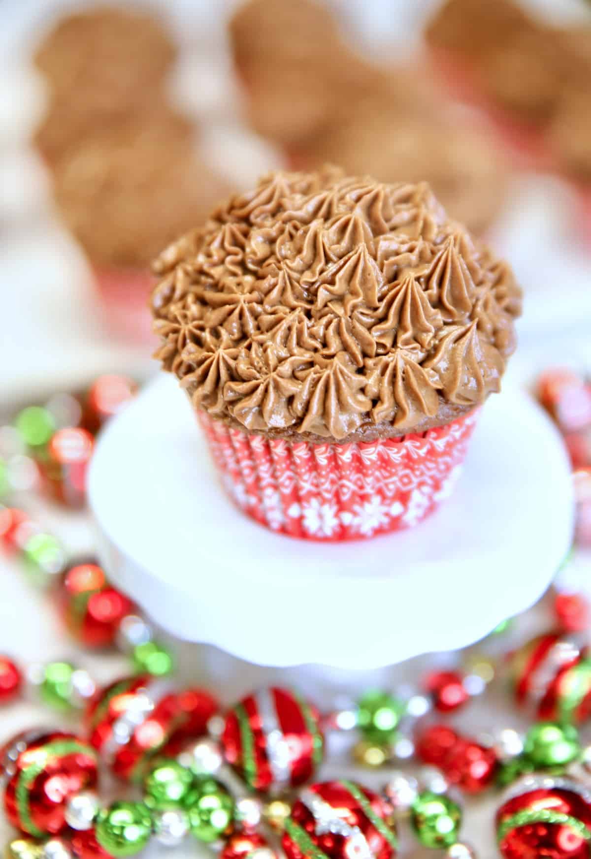 Chocolate cupcake on a pedestal, Christmas garland around bottom.