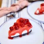 Cherry cheesecake slice on a plate.