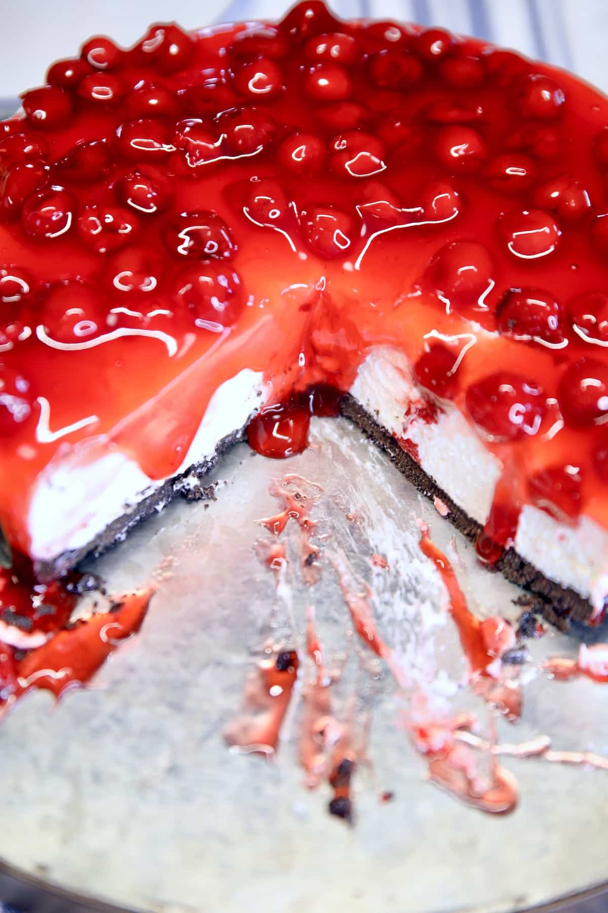 Cherry cheesecake on a platter, 2 slices removed.