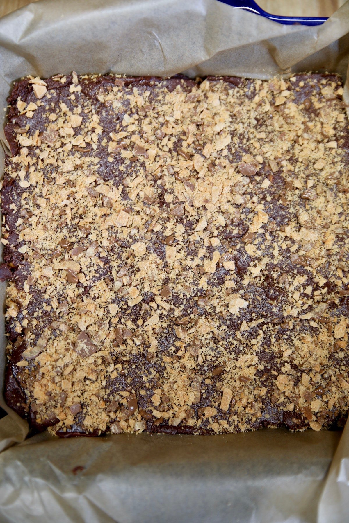 Chocolate fudge with crushed Butterfingers in a square pan.