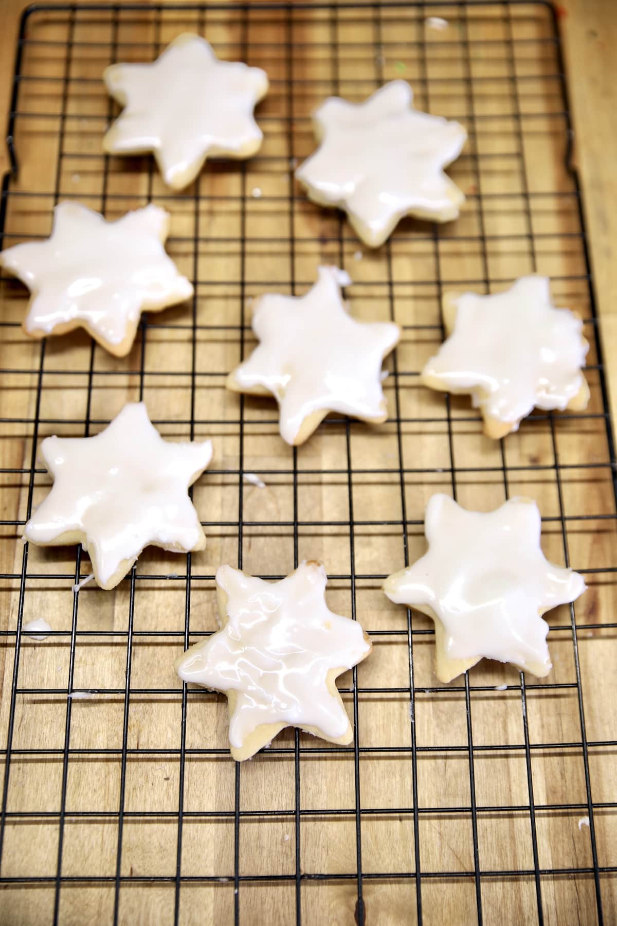 Star cookies with icing on a wire rack.