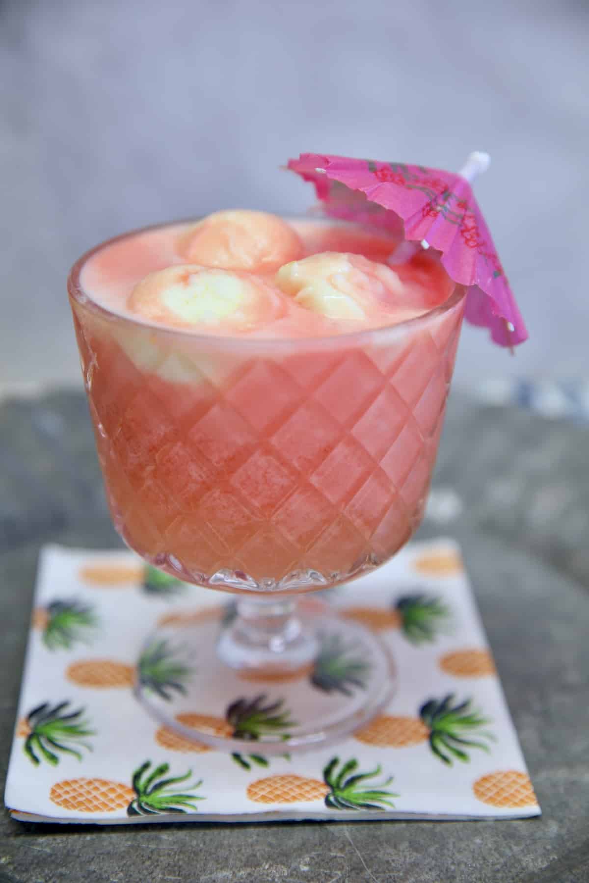 Sherbet punch in a glass with drink umbrella.