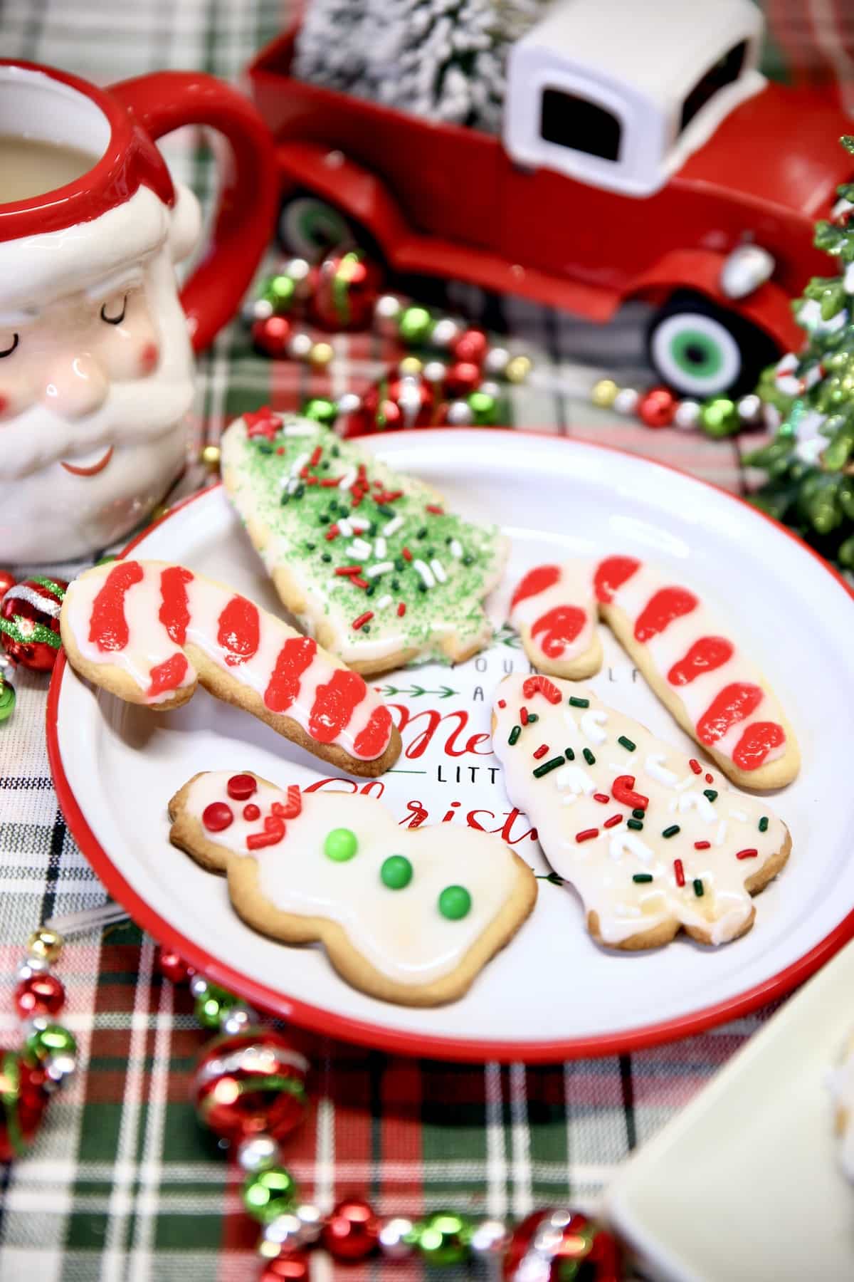 Plate of decorated sugar cookies with Christmas decor.