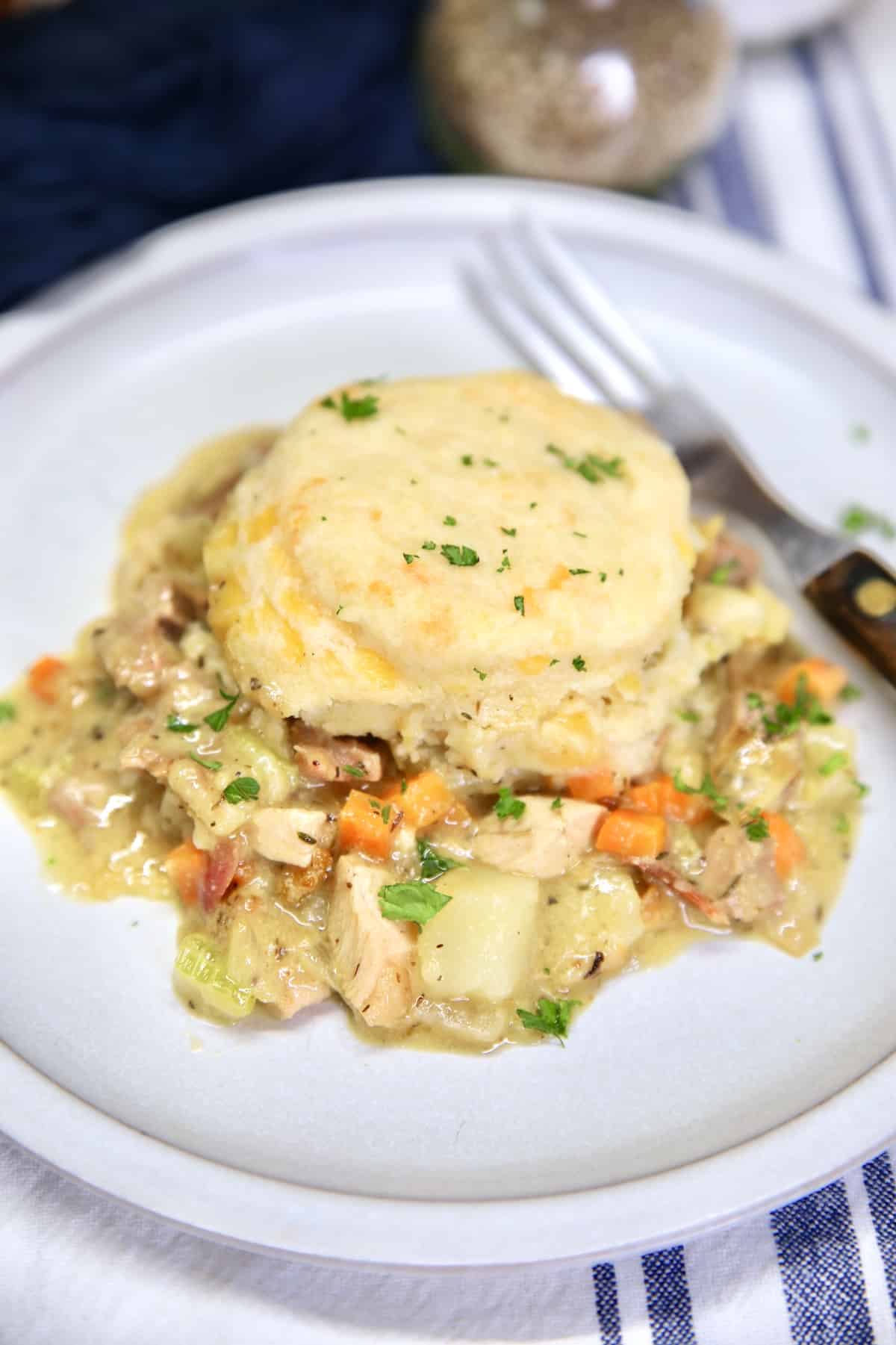 Chicken and biscuit casserole on a plate with a fork.