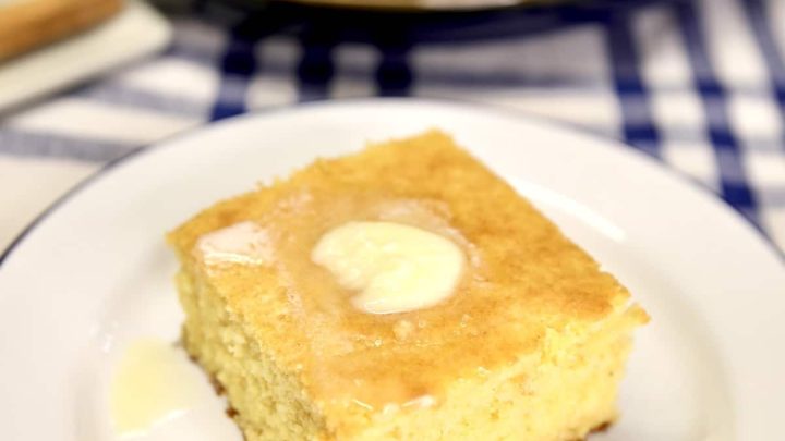 Slice of cornbread with pat of butter on top.