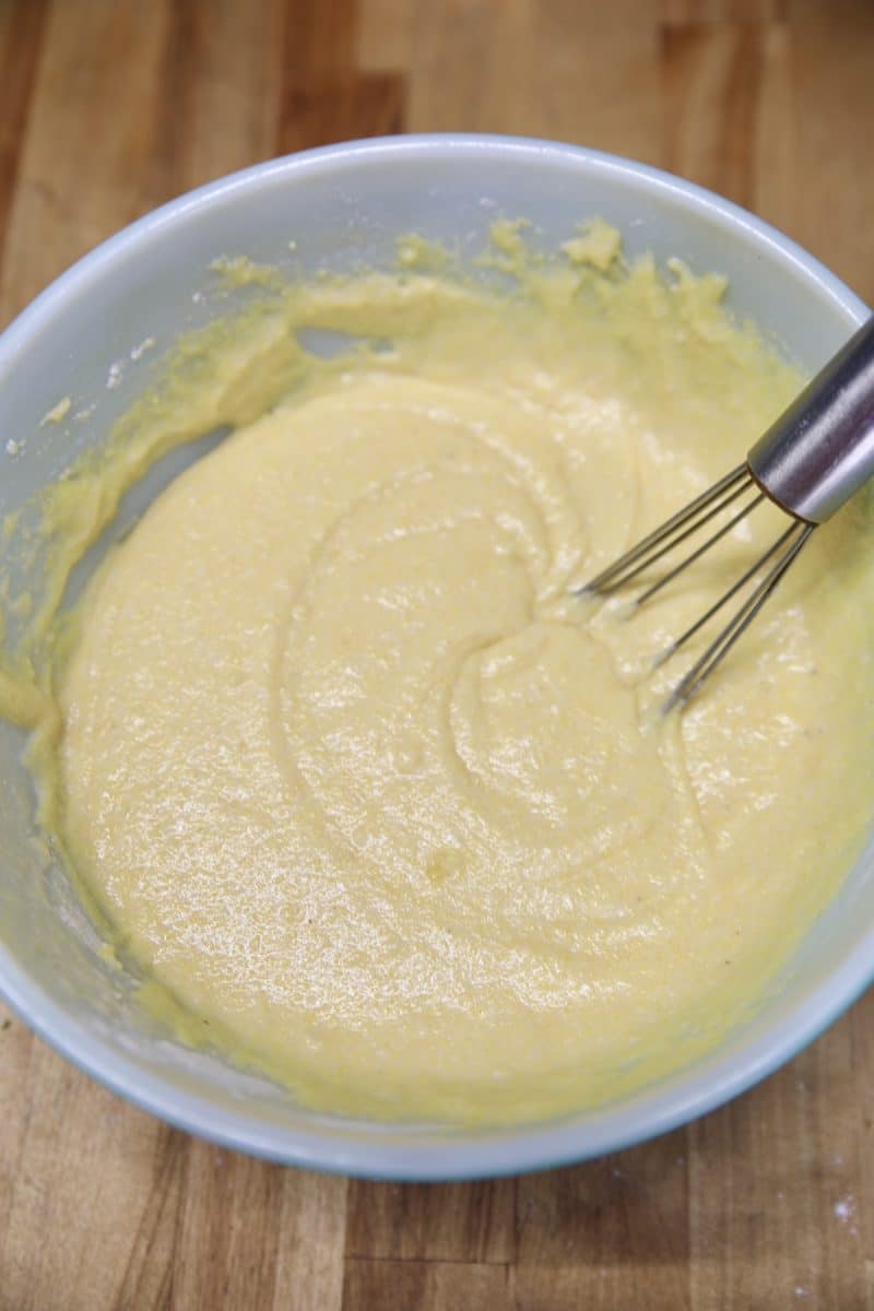 Cornmeal batter with a whisk in a bowl.