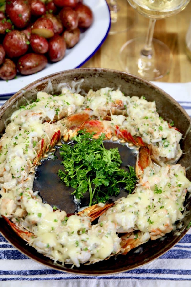 Lobster thermidor in a skillet, parsley garnish in center.