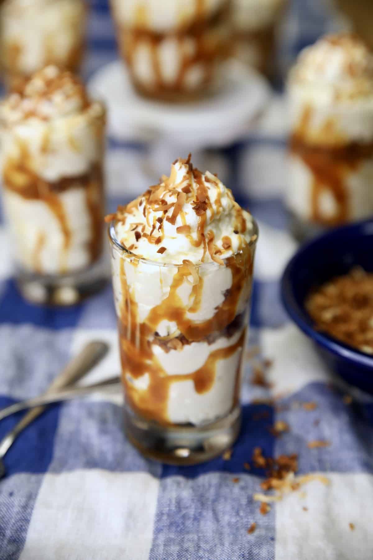 Dessert glasses with coconut cheesecake, caramel drizzle.
