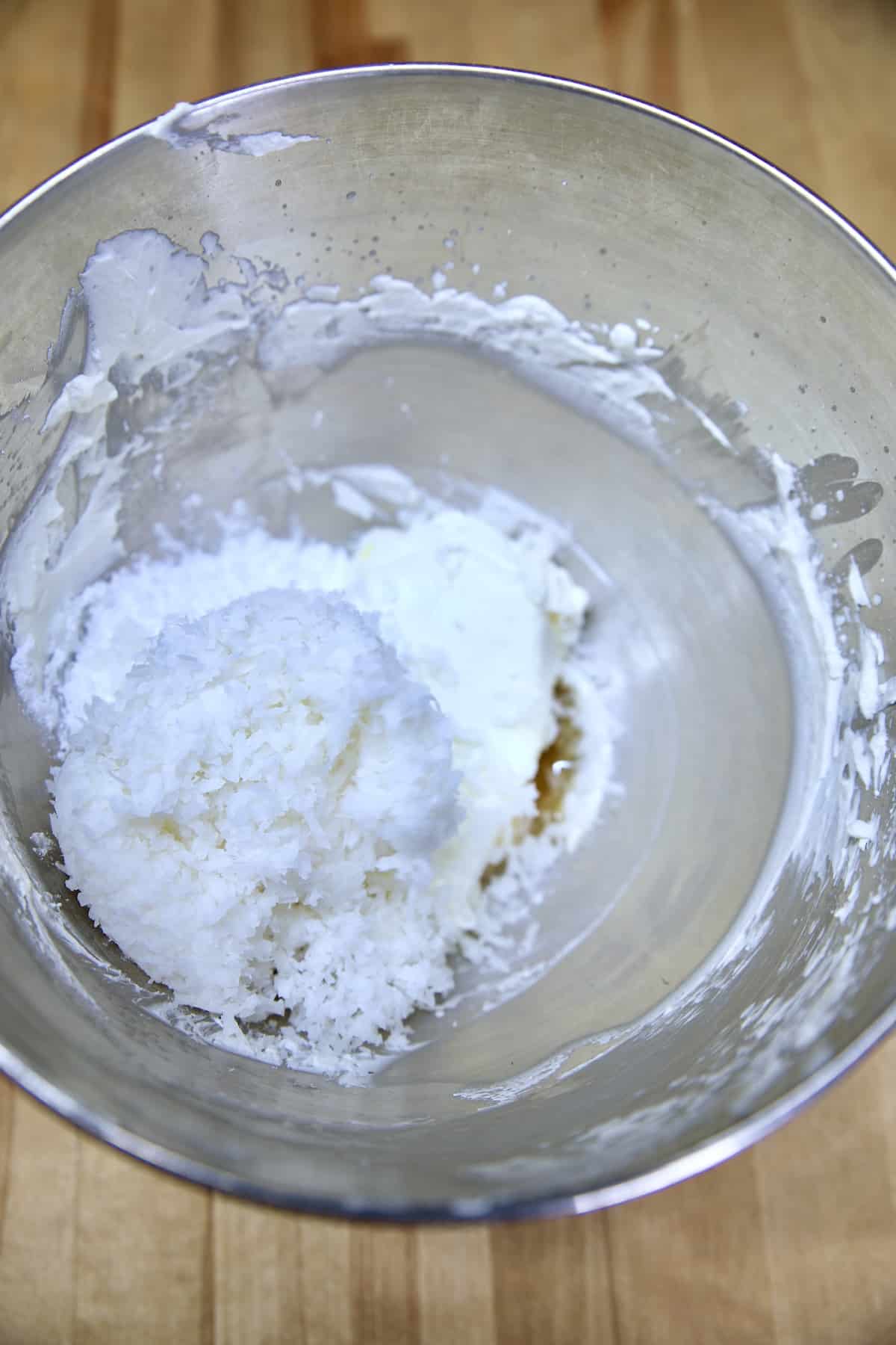 Coconut and cream cheese in a mixer bowl.