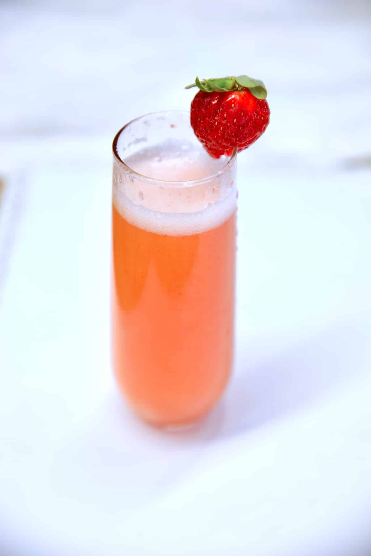 Strawberry mimosa in a stemless champagne flute.