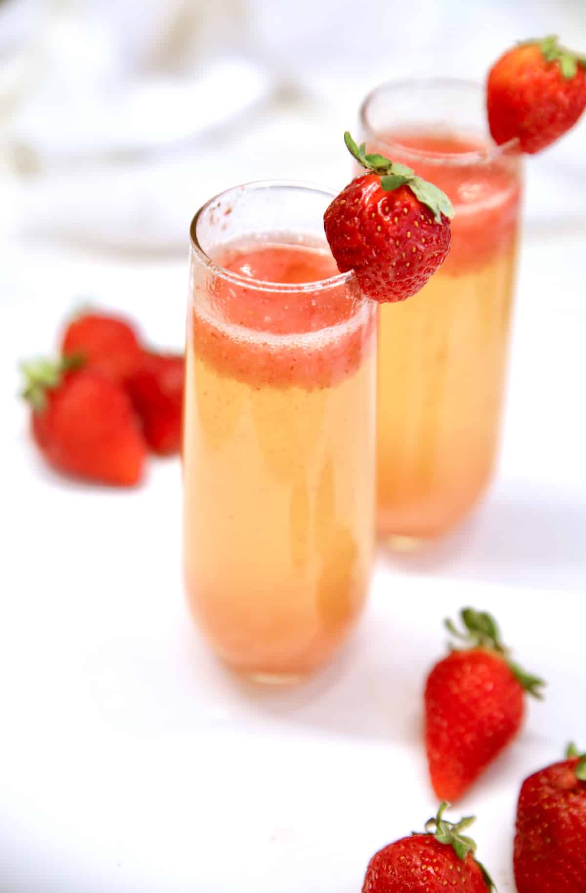 Strawberry champagne cocktails with strawberry garnish.
