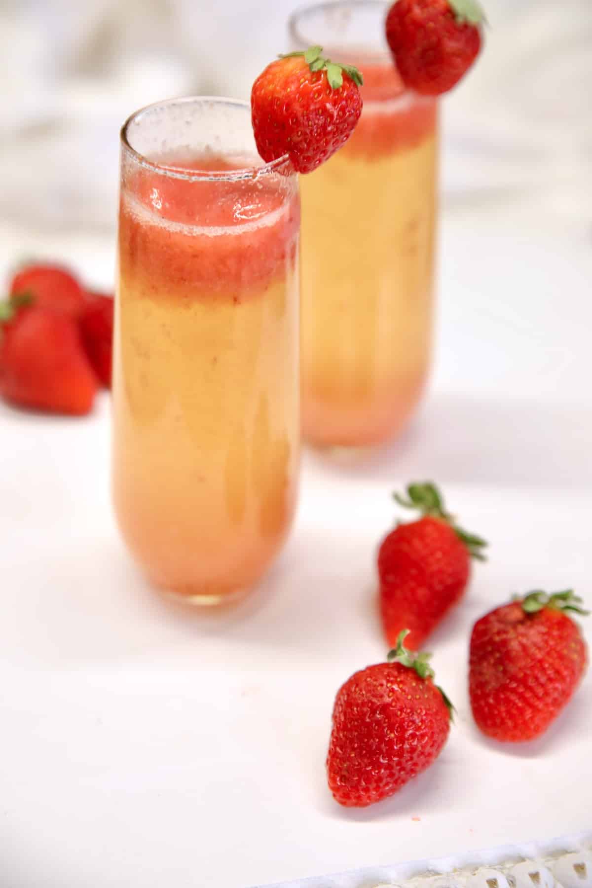 2 strawberry mimosas cocktails in champagne glasses.