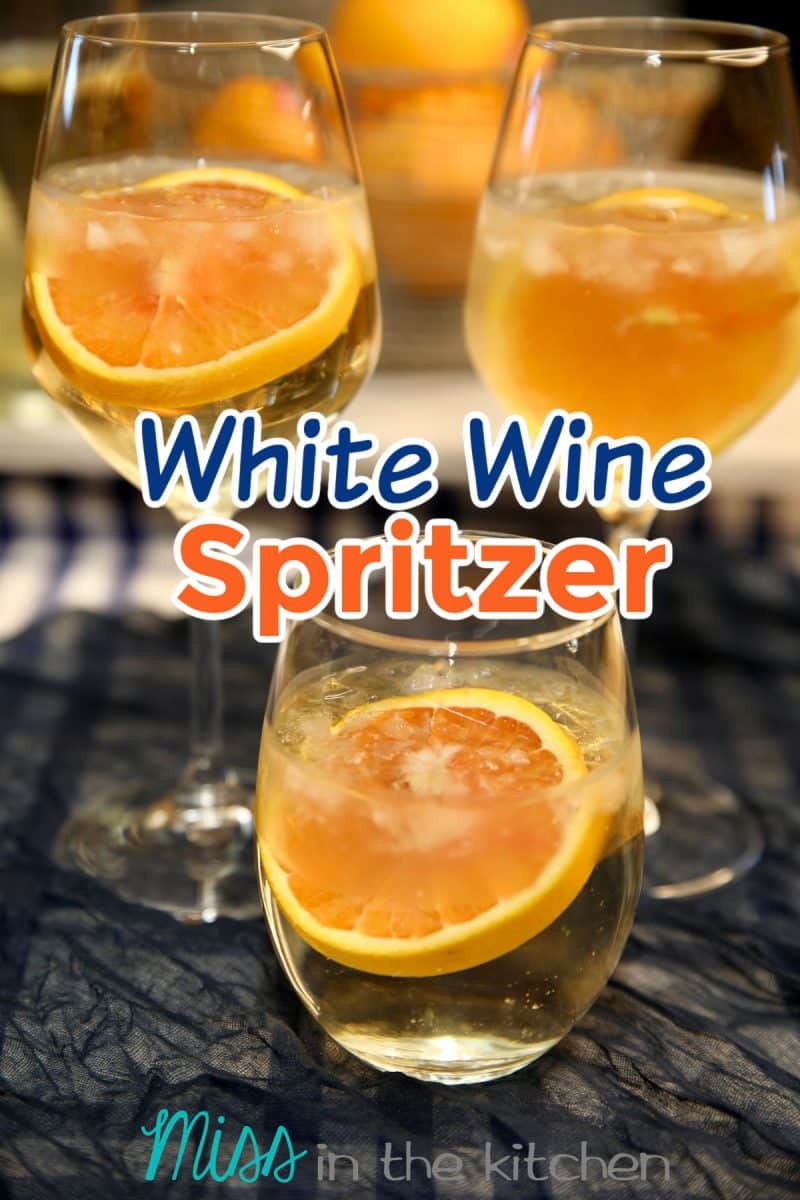 3 white wine spritzers with orange garnish. Text overlay.