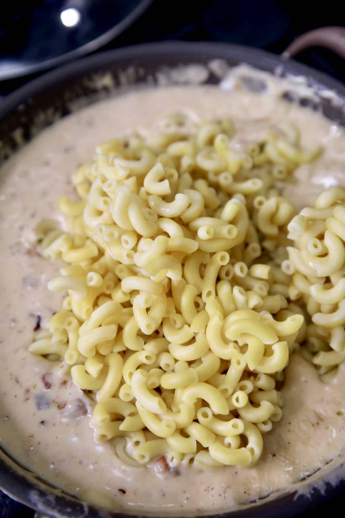 Pan with cheese sauce, stirring in cooked macaroni.