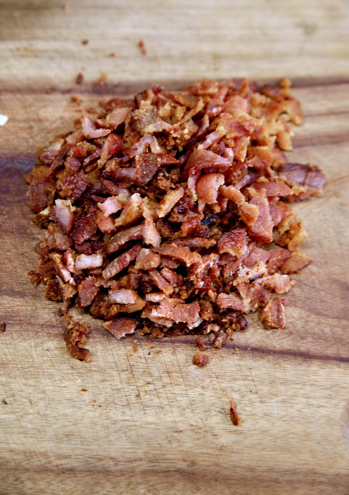 Chopped crispy bacon on a cutting board.