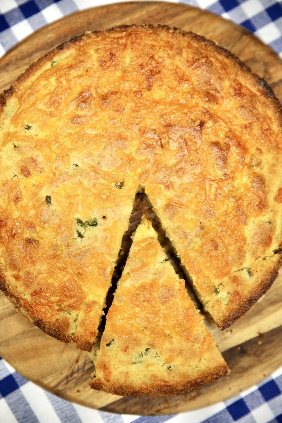 Overhead view of round jalapeno cheddar cornbread, one wedge sliced.