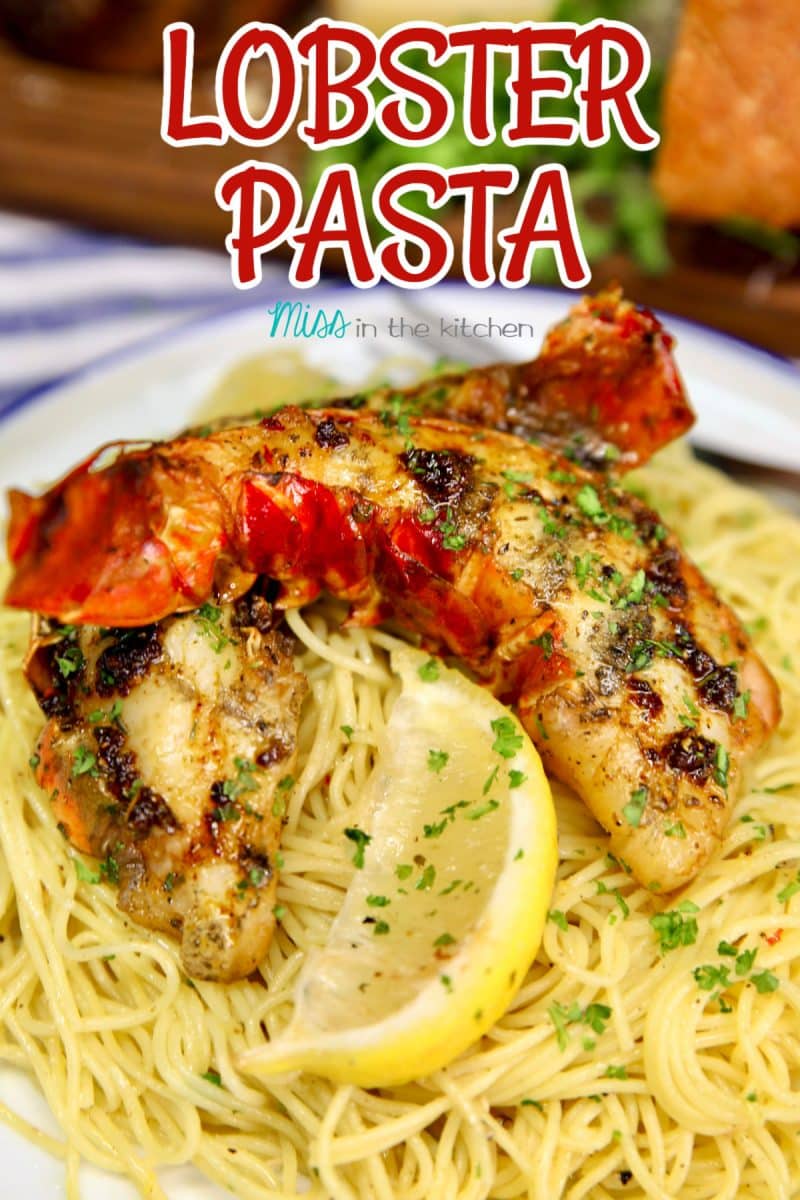 Lobster tails over pasta on a plate.