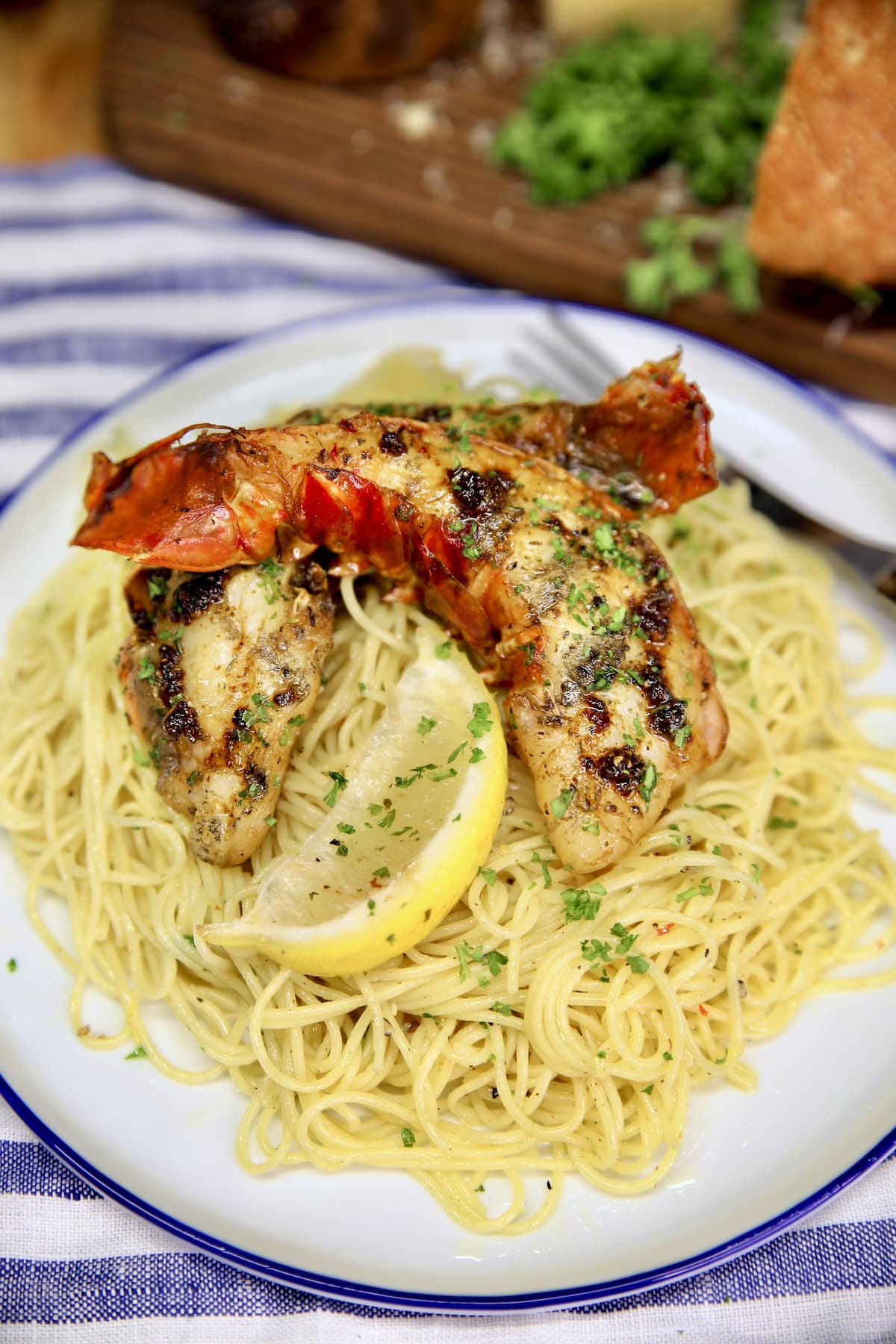 Lobster tails with lemon pasta on a plate.