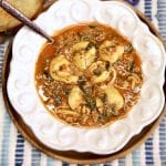 Bowl of tomato tortellini soup with spoon.