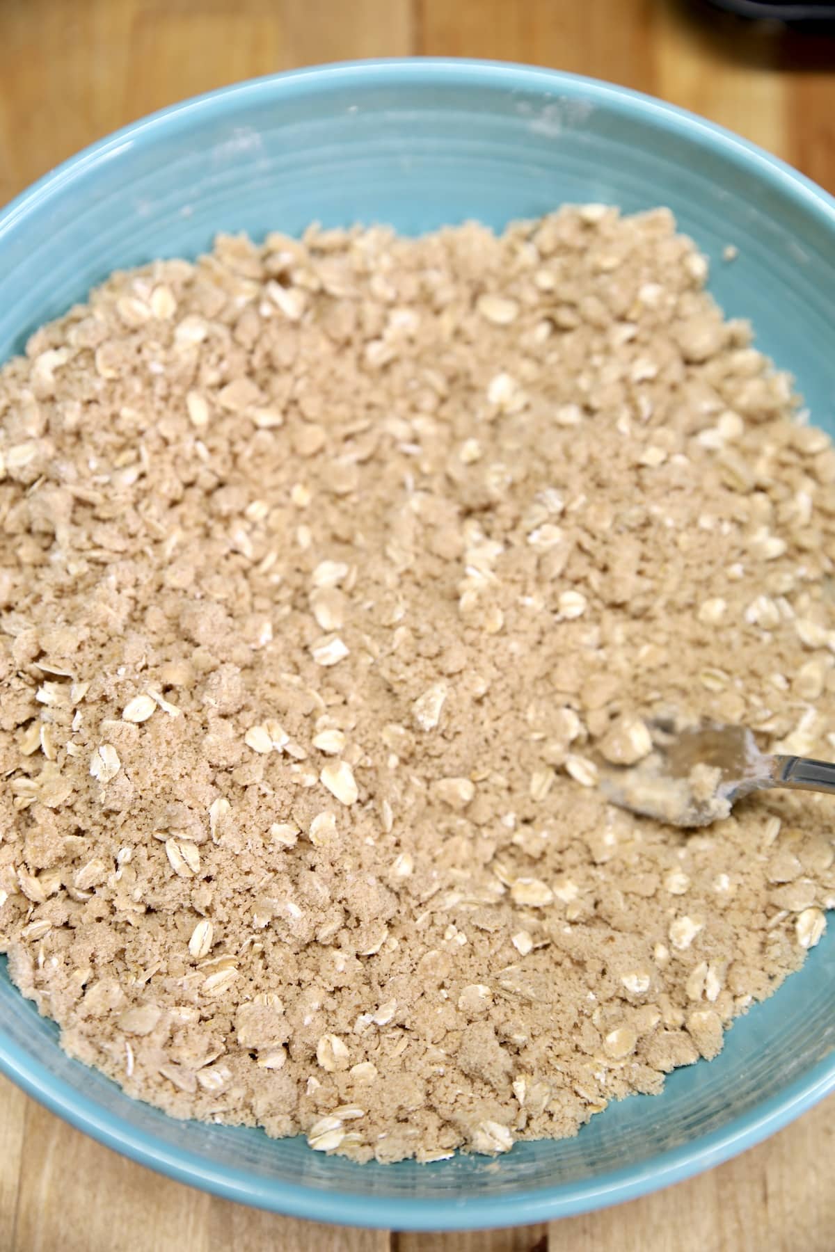 Brown sugar oat crisp topping in a bowl with a fork.