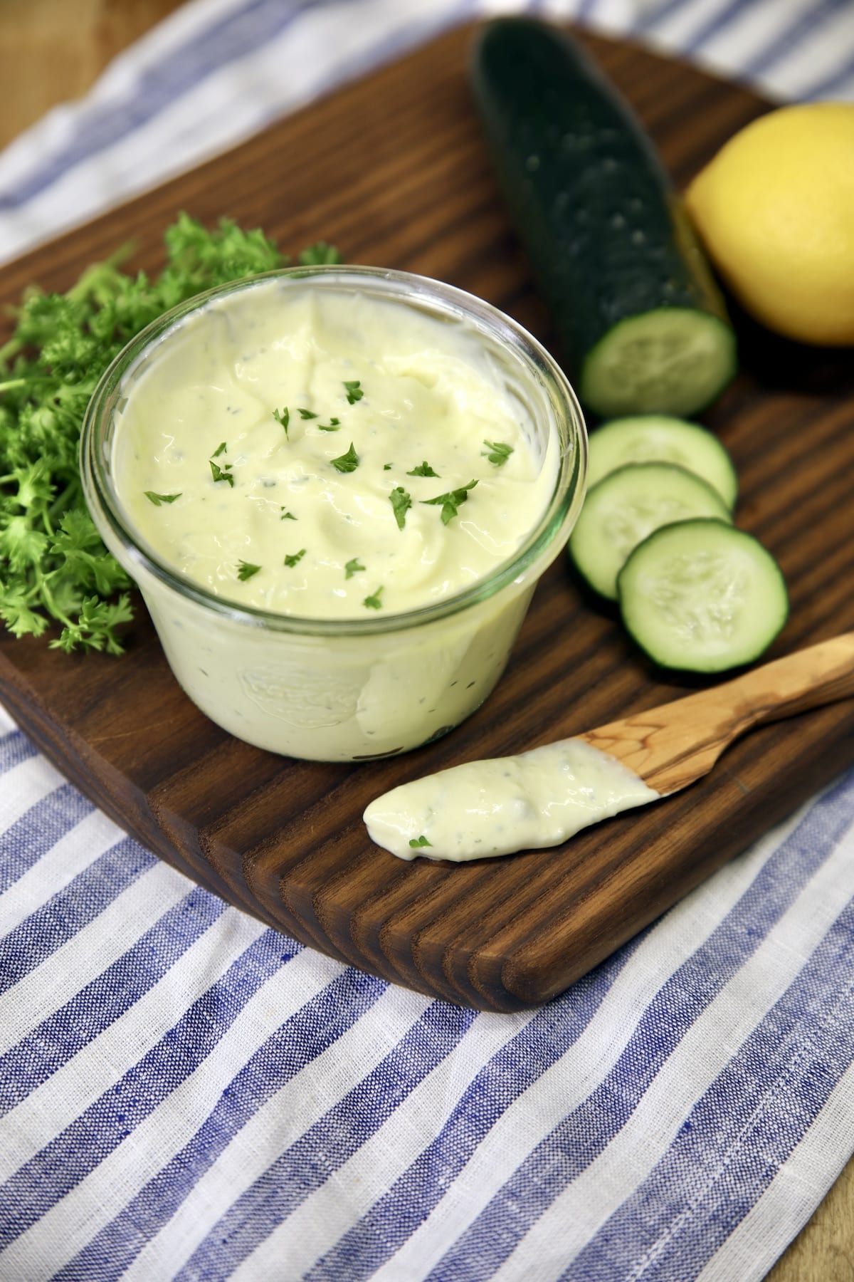 Jar of mayonnaise with sliced cucumbers and knife with mayo.