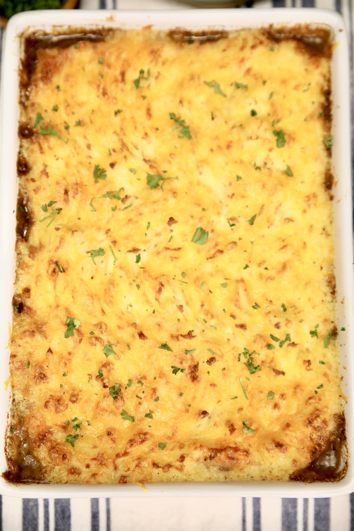 Rectangle casserole dish with  baked cottage pie. 
