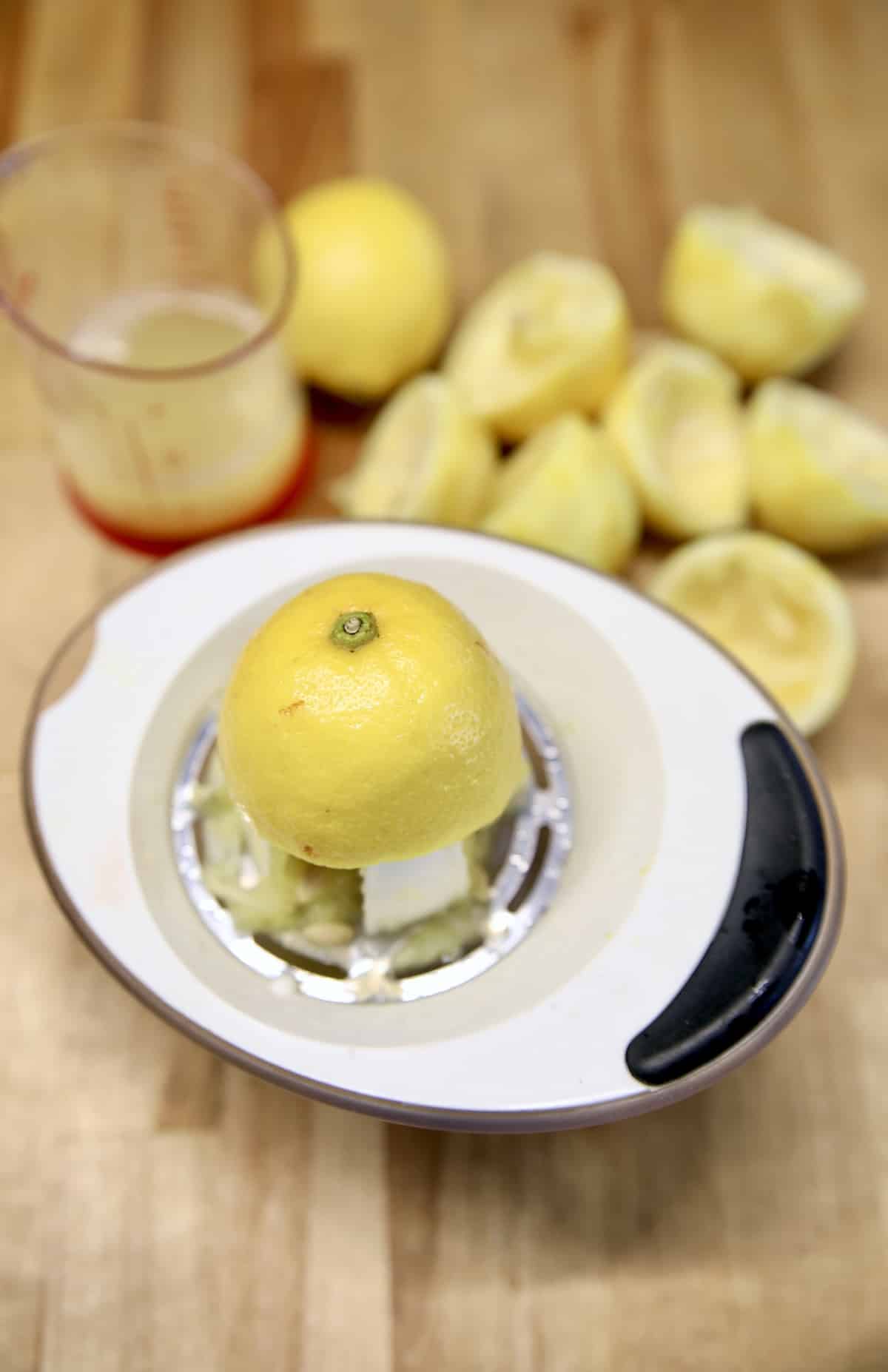 Juicing lemons with measuring cup of juice.