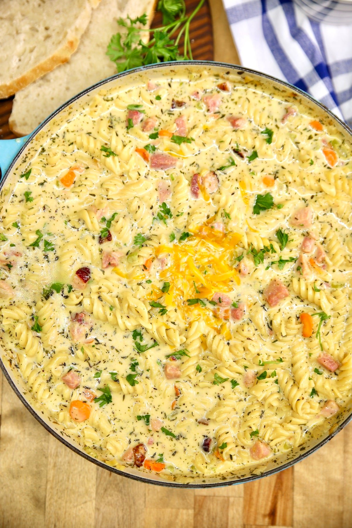 Pan of ham and cheese soup with vegetables and pasta.