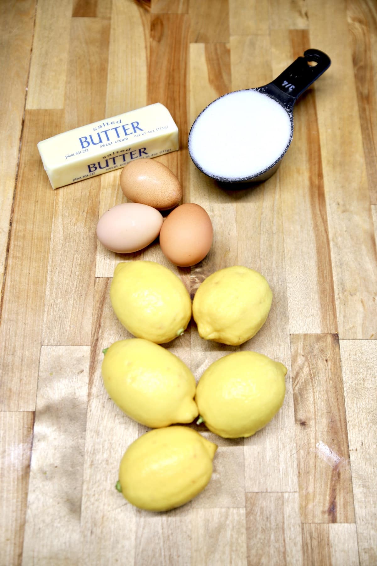 Ingredients for lemon curd: butter, sugar, eggs, lemons.