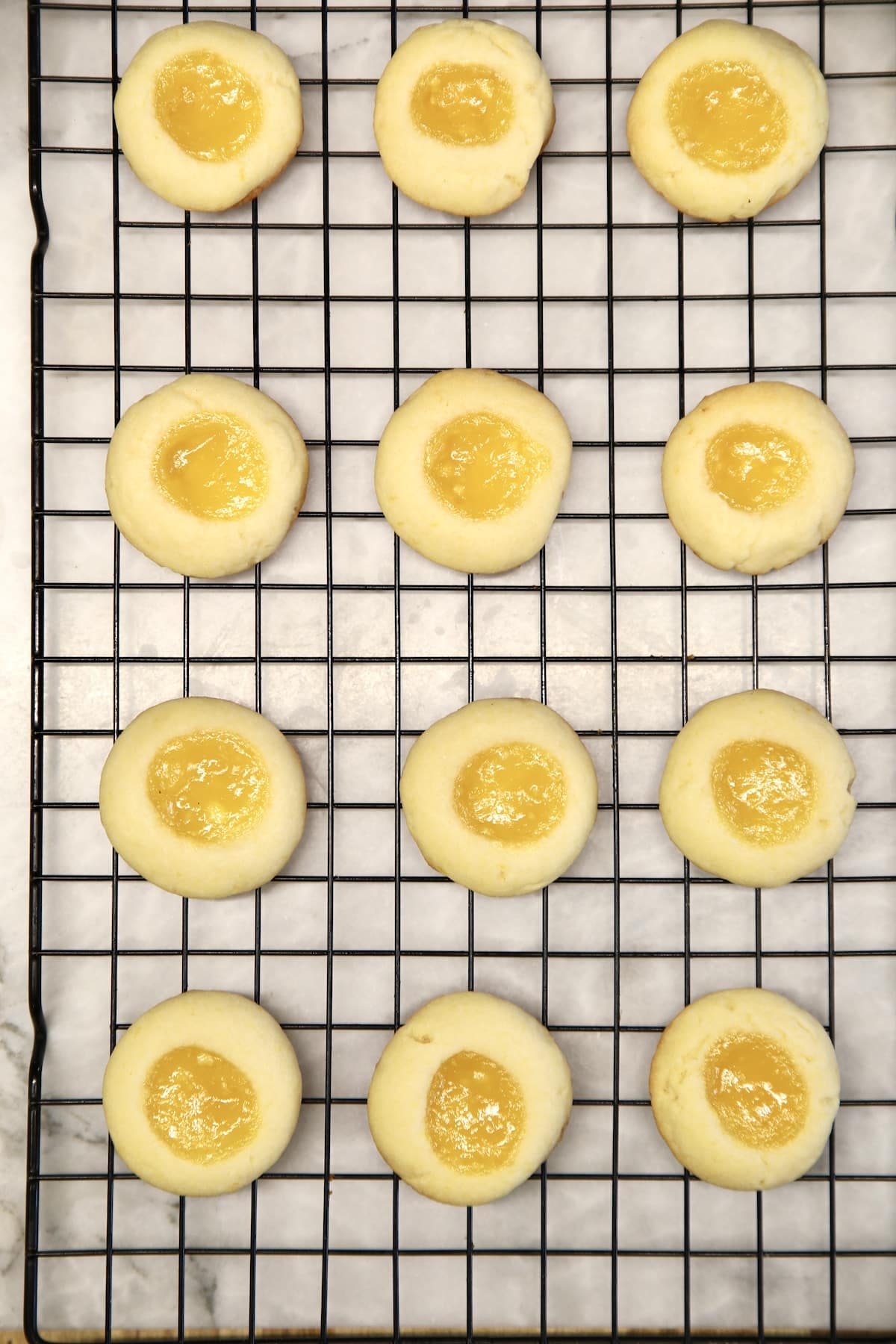 Lemon curd cookies cooling on a wire rack.