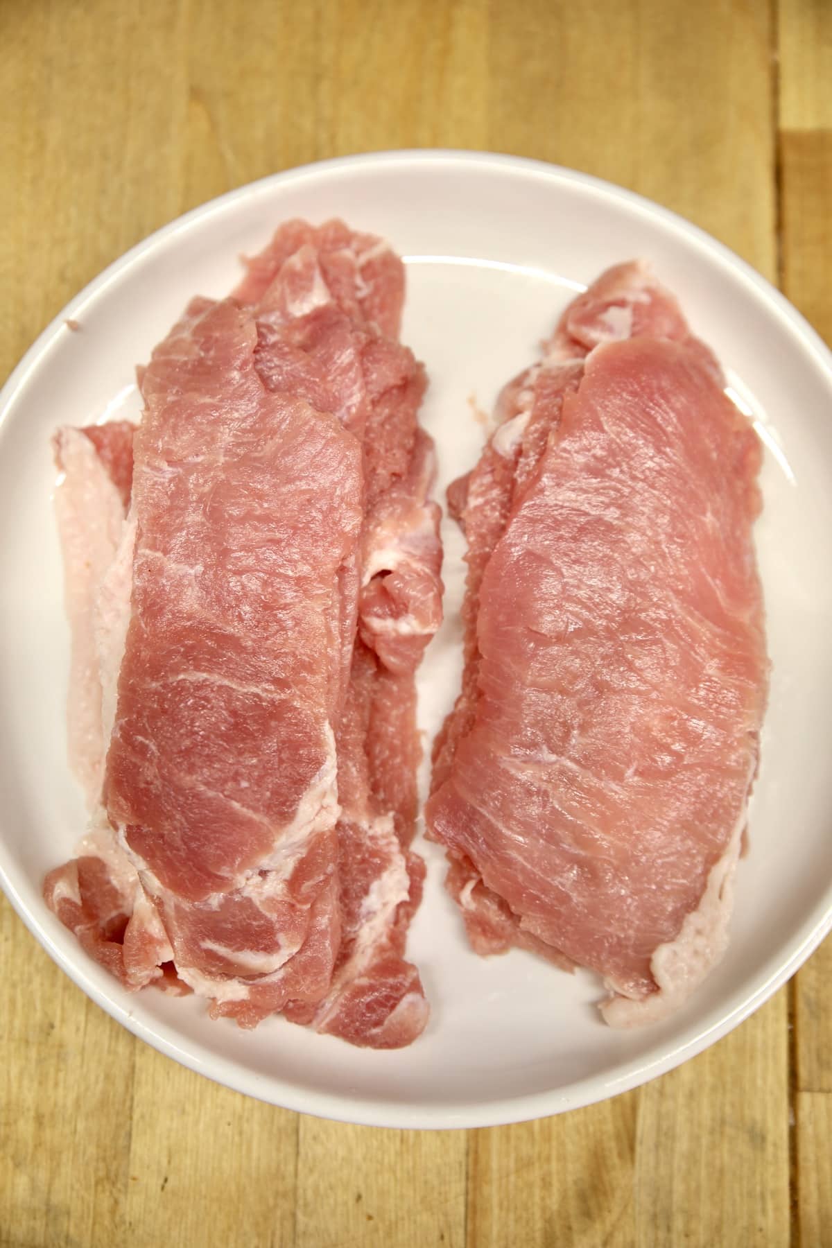 Thin sliced pork cutlets on a plate.