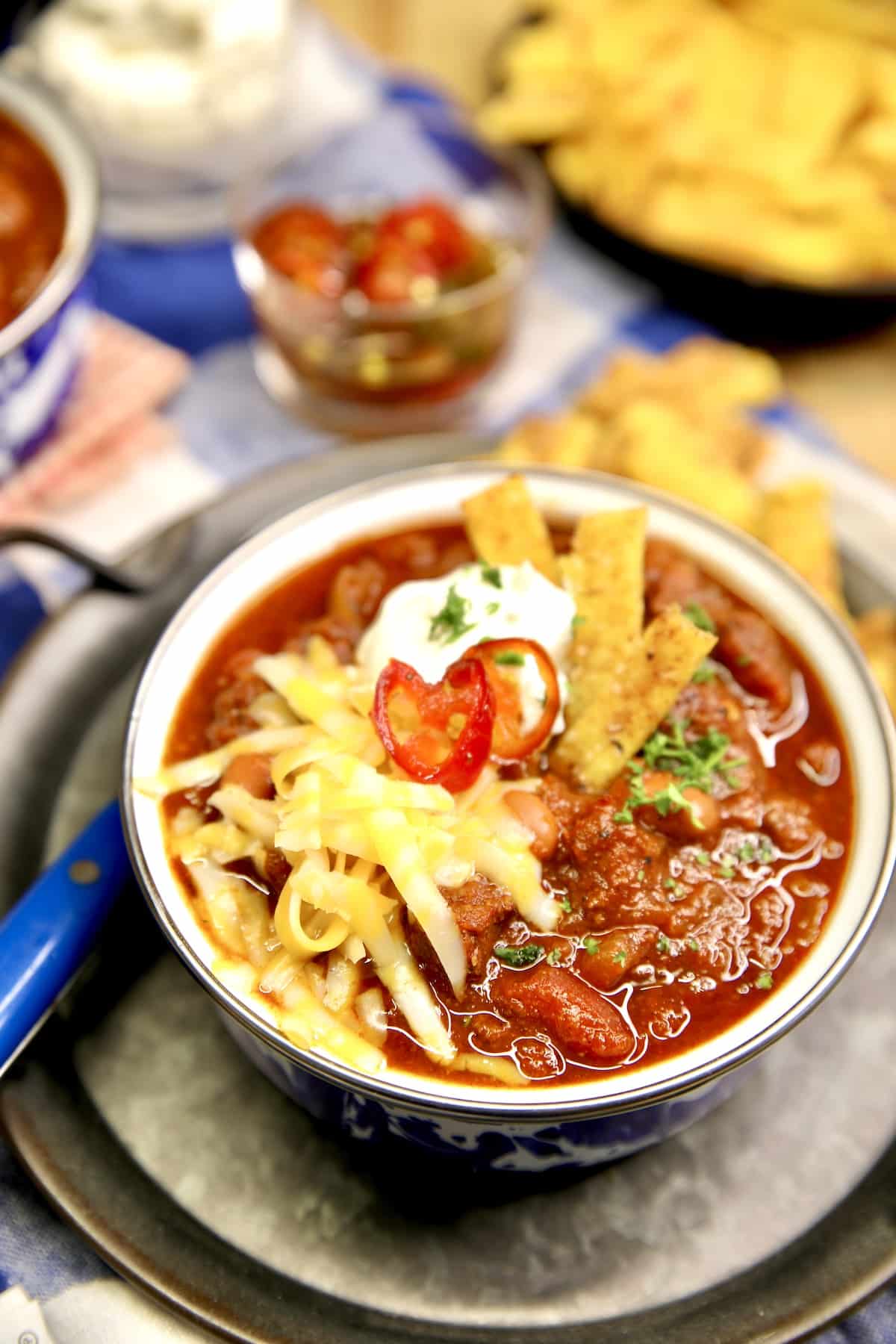 Bowl of chili with fritos, cheese, jalapenos and sour cream.
