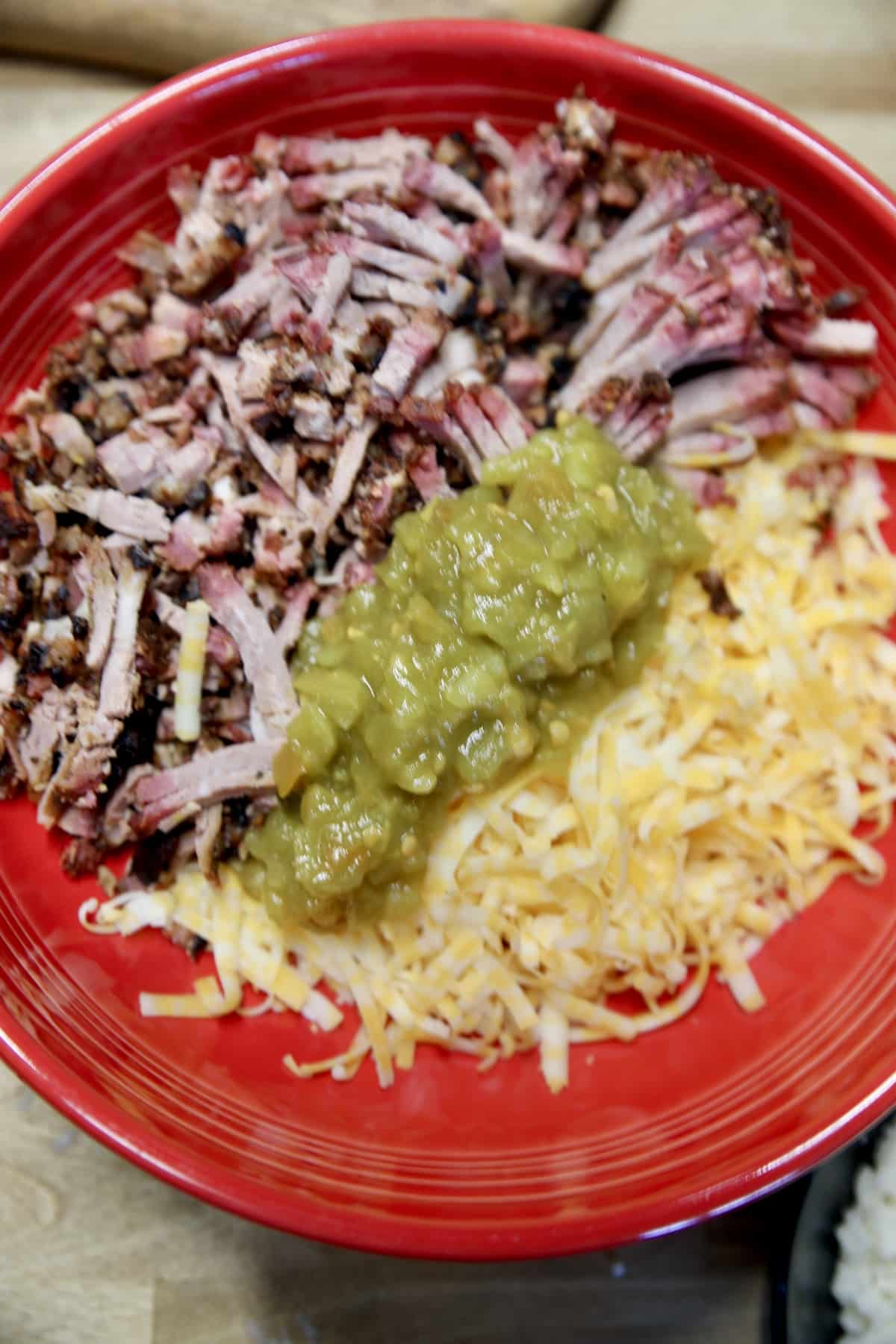 Bowl with chopped brisket, shredded cheese and green chiles.