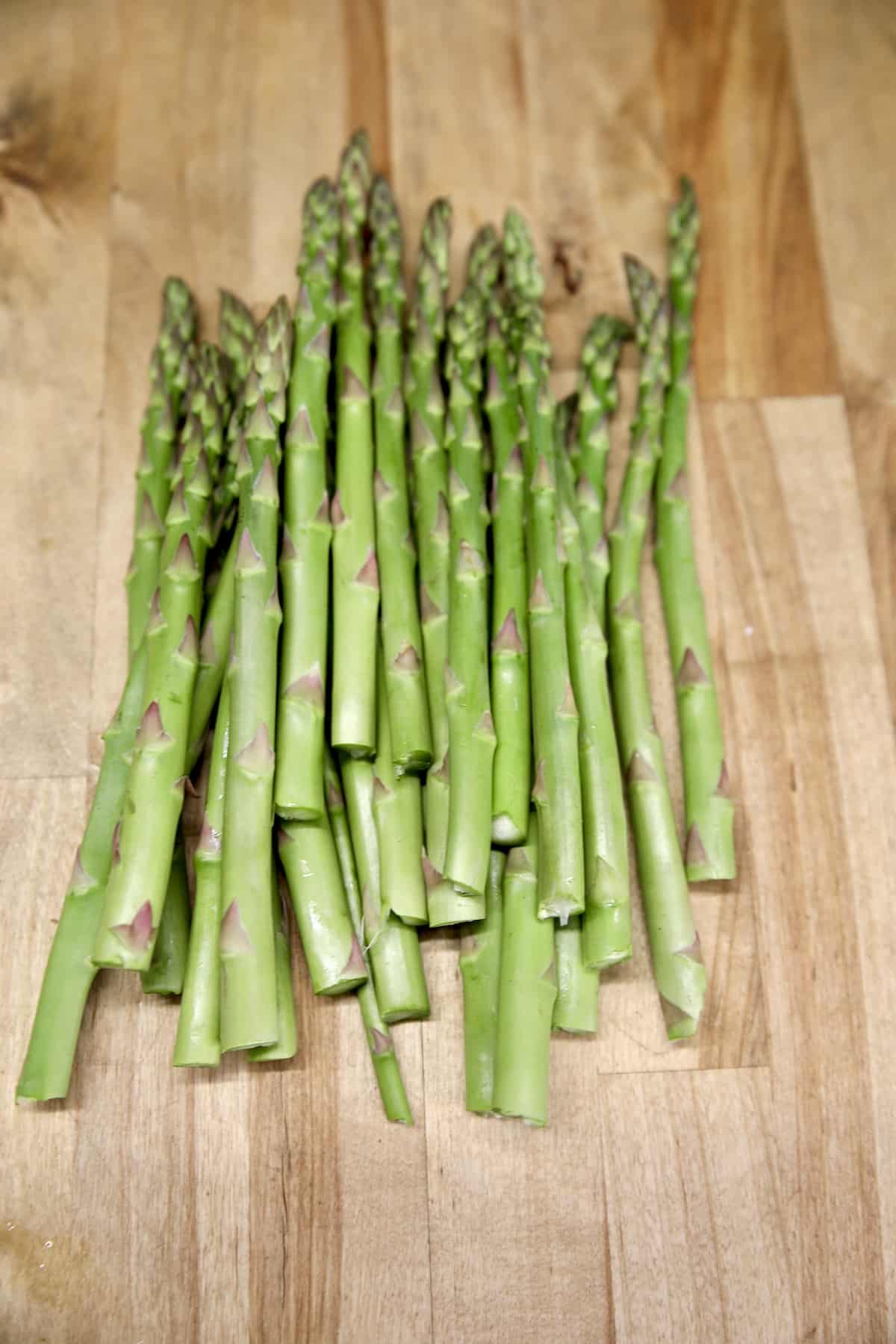 Asparagus stalks on wood counter top.