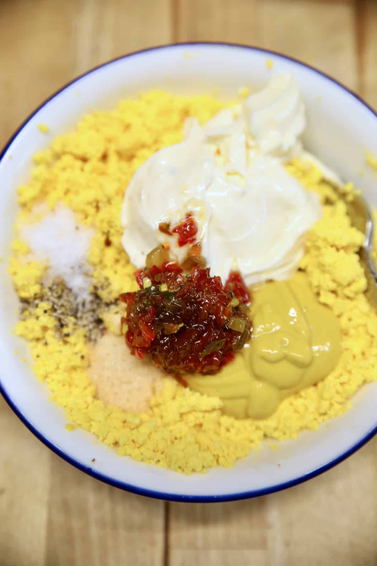 Bowl of egg yolks, mayo, mustard, jalapenos. 