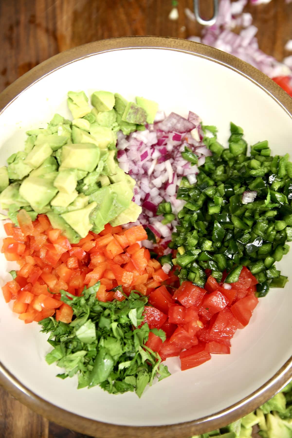 Bowl of chopped vegetables for avocado salsa.