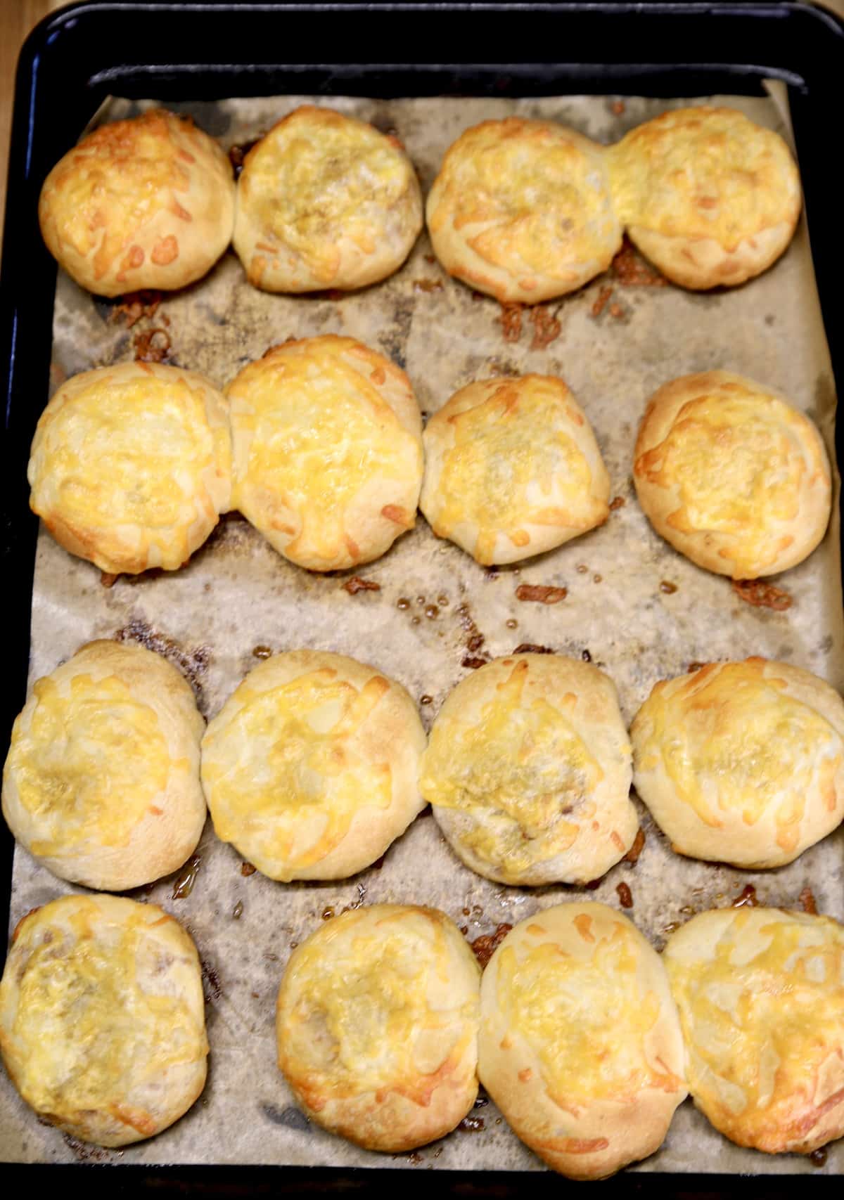 Cheesy taco biscuit bombs on a baking sheet.